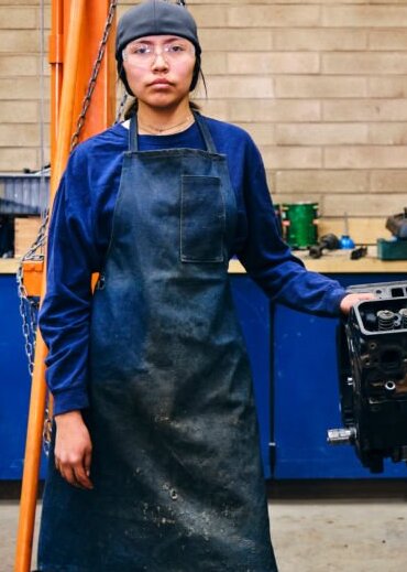 A teenage Native American Navajo girl, in an automotive workshop at a high school.